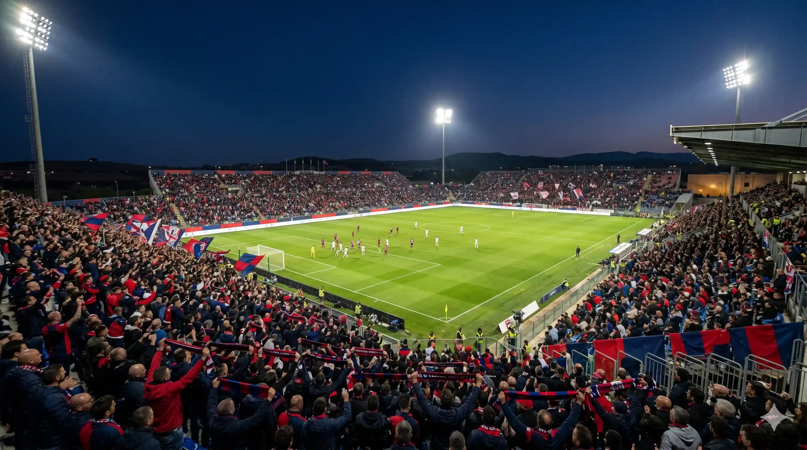Cagliari fans in red and blue filling the Unipol Domus in Sardinia night.